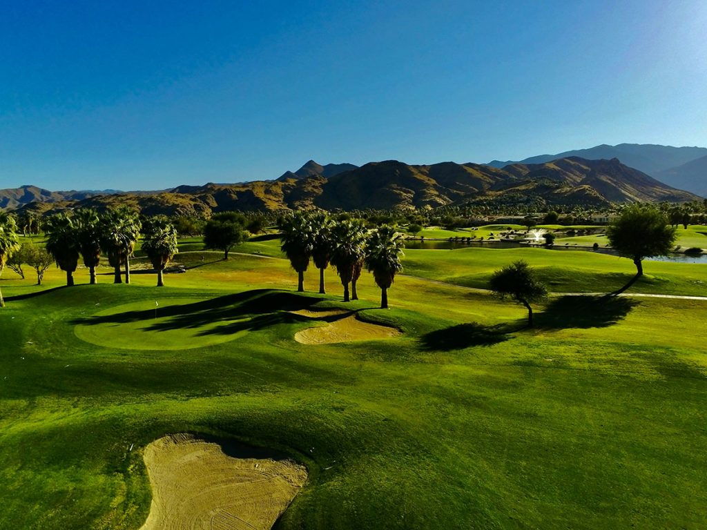 Panoramic view of a lush green golf course at Bay Palms Golf Complex. Smooth