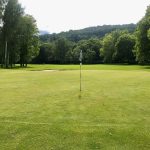 Panoramic view of a lush green golf course at Bent Creek Golf Course. Smooth