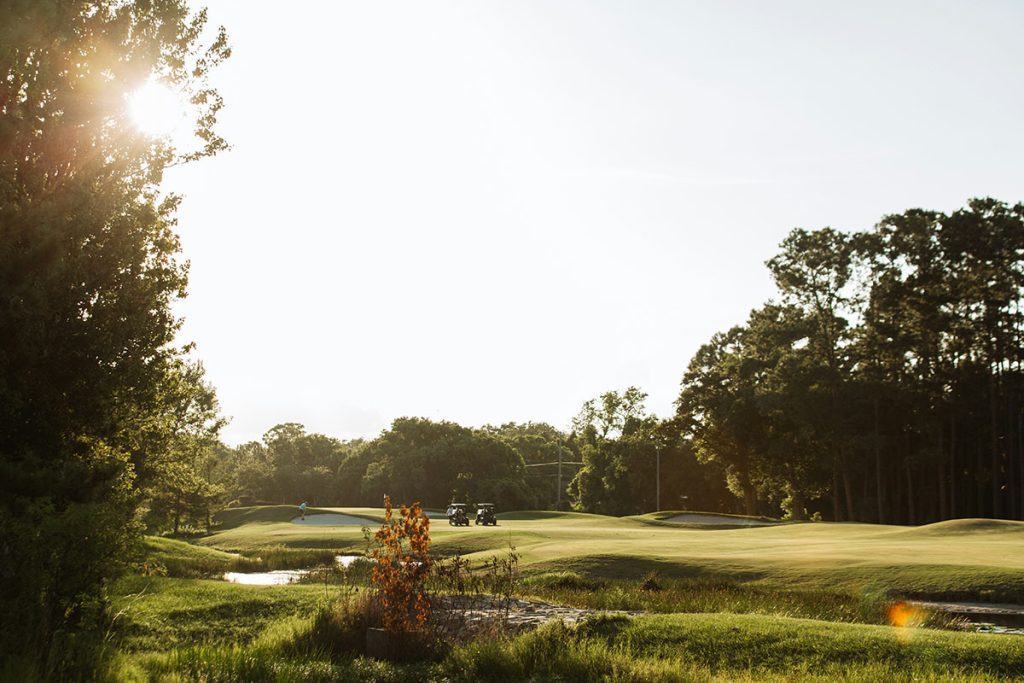 Panoramic view of a lush green golf course at Berksdale Golf Course. Smooth