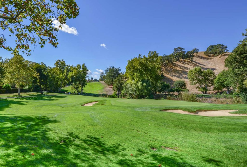 Panoramic view of a lush green golf course at Breckinridge Golf Course. Smooth