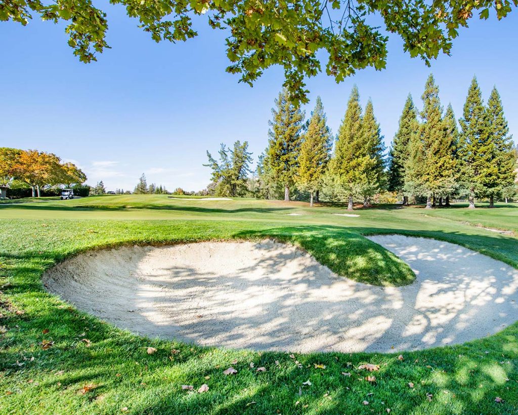 Panoramic view of a lush green golf course at Caloosa Golf & Country Club. Smooth