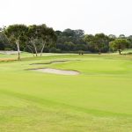 Panoramic view of a lush green golf course at Cerbat Cliffs Golf Course. Smooth