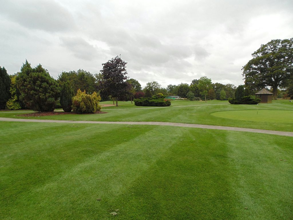 Panoramic view of a lush green golf course at Greenbrier Golf & Country Club. Smooth