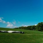 Panoramic view of a lush green golf course at Hayden Lake Country Club. Smooth