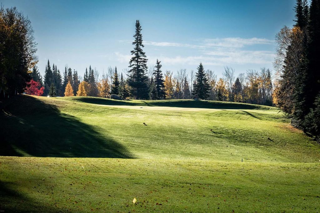 Panoramic view of a lush green golf course at Otter Creek Golf Course. Smooth