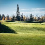 Panoramic view of a lush green golf course at Otter Creek Golf Course. Smooth