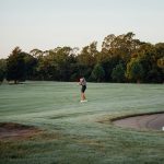 Panoramic view of a lush green golf course at Pin High Indoor Golf. Smooth