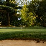 Panoramic view of a lush green golf course at Pine Bluff Country Club. Smooth