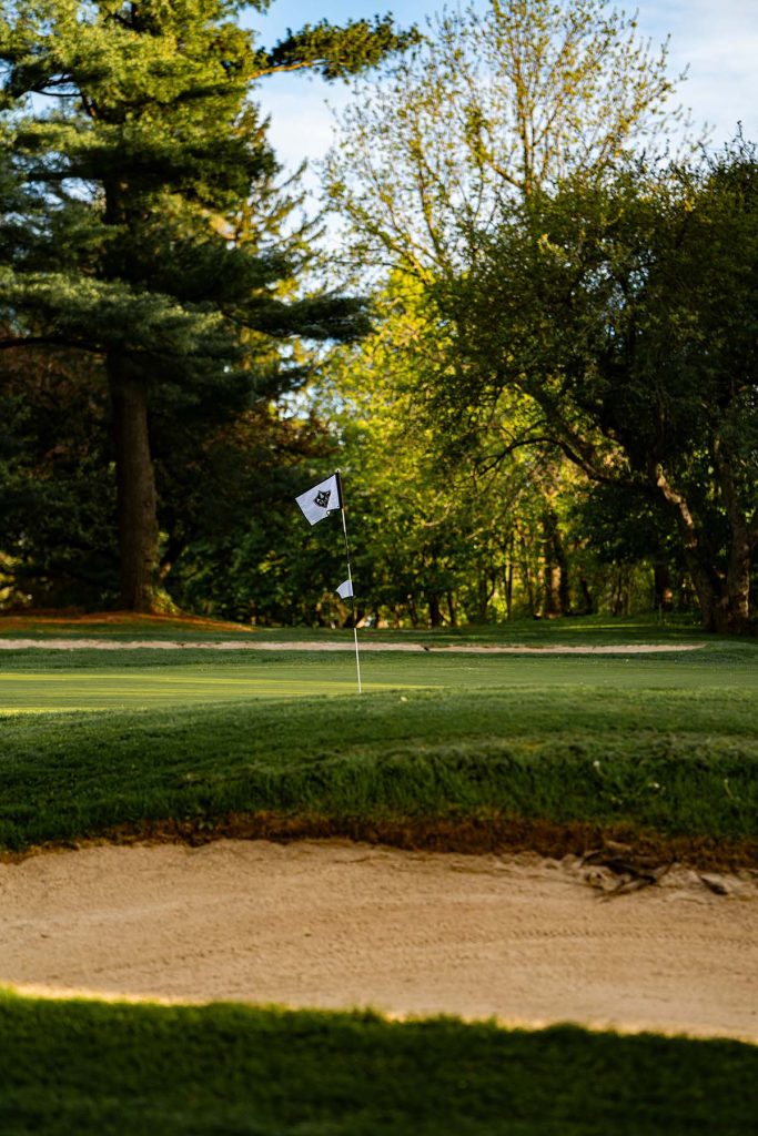 Panoramic view of a lush green golf course at Pine Bluff Country Club. Smooth