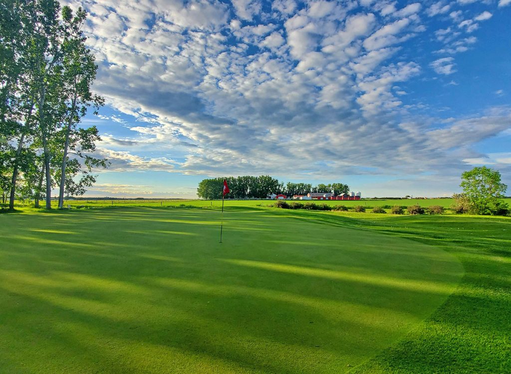 Panoramic view of a lush green golf course at Rustic Ridge Golf Course. Smooth