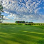 Panoramic view of a lush green golf course at Rustic Ridge Golf Course. Smooth