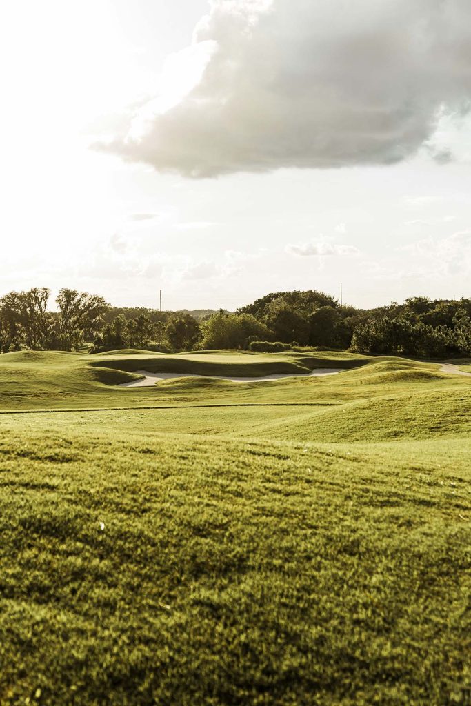 Panoramic view of a lush green golf course at Southern Oaks Championship Golf Course. Smooth