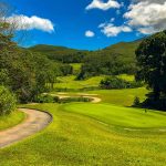 Panoramic view of a lush green golf course at Sun Valley Golf Course. Smooth