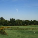 Panoramic view of a lush green golf course at The Glen Club. Smooth