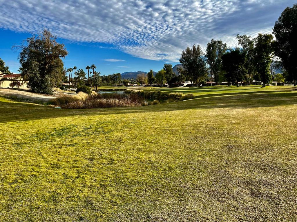 Panoramic view of a lush green golf course at The Valley Club. Smooth