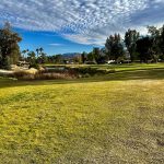 Panoramic view of a lush green golf course at The Valley Club. Smooth