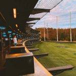 Panoramic view of a lush green golf course at Topgolf Rogers. Smooth