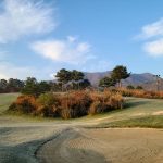 Panoramic view of a lush green golf course at Warrior Hills Golf Course. Smooth