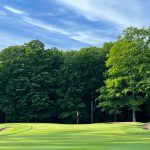 Panoramic view of a lush green golf course at Wedgewood Golf Course. Smooth