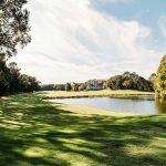 Panoramic view of a lush green golf course at Wilmington Country Club. Smooth