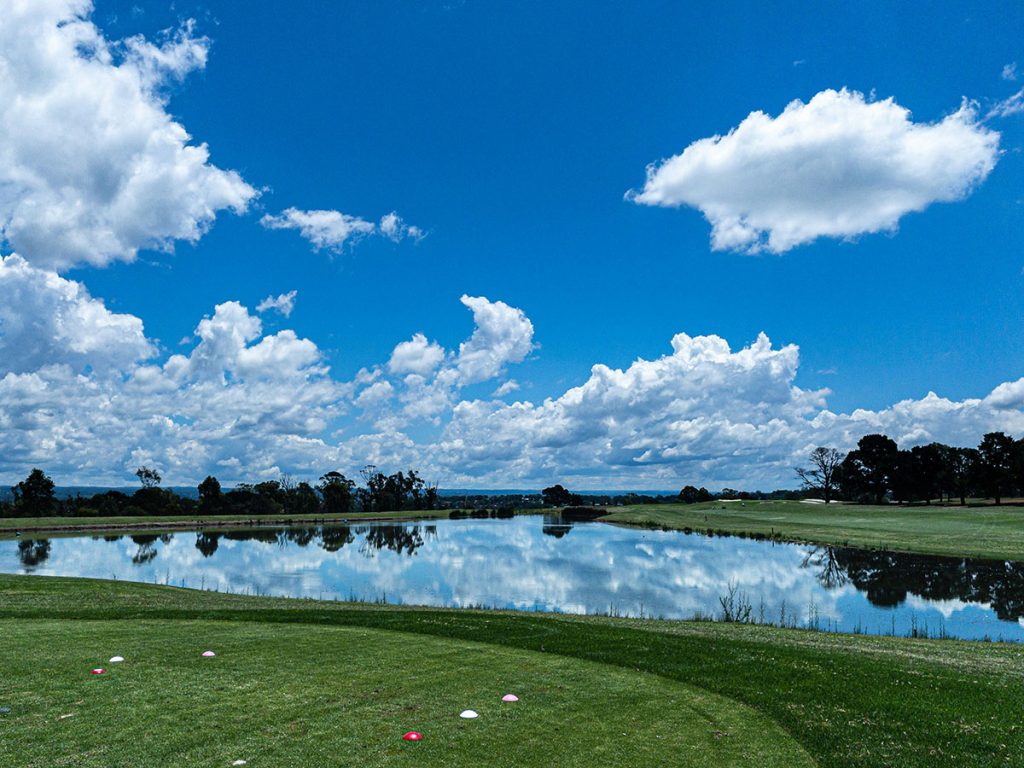 Panoramic view of a lush green golf course at York Golf & Tennis Club. Smooth
