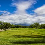 Panoramic view of a lush green golf course at 360 Ewa Beach Country Club. Smooth