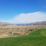 Panoramic view of a lush green golf course at Alta Lake Golf Resort. Smooth