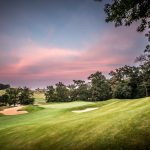 Panoramic view of a lush green golf course at Amana Colonies Golf Club. Smooth