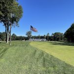 Panoramic view of a lush green golf course at American Dunes Golf Club. Smooth