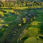 Panoramic view of a lush green golf course at Anaconda Hills Golf Course. Smooth