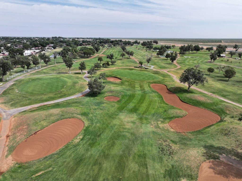 Panoramic view of a lush green golf course at Andrews County Golf Course. Smooth