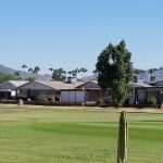Panoramic view of a lush green golf course at Apache Wells Country Club. Smooth