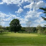 Panoramic view of a lush green golf course at Apple Hill Golf Course. Smooth