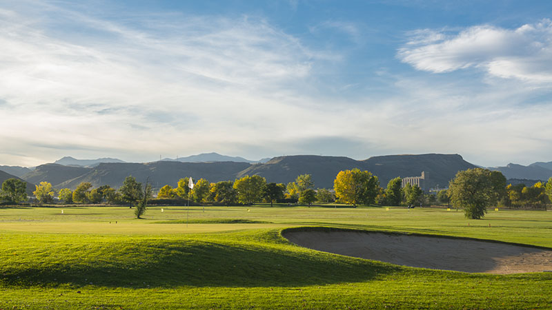 Panoramic view of a lush green golf course at Applewood Golf Course. Smooth