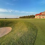 Panoramic view of a lush green golf course at Arcadia Bluffs South Course. Smooth