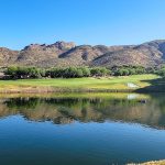 Panoramic view of a lush green golf course at Arizona National Golf Club. Smooth