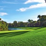 Panoramic view of a lush green golf course at Arthur Hills Golf Course. Smooth