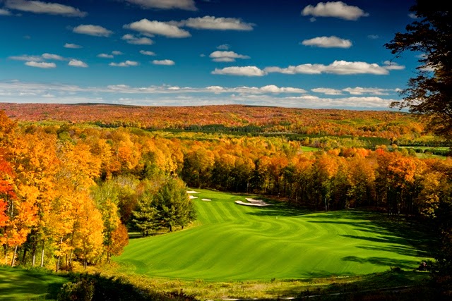 Panoramic view of a lush green golf course at Arthur Hills Golf Course. Smooth