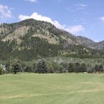 Panoramic view of a lush green golf course at Aspen Hills Golf Course. Smooth