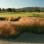 Panoramic view of a lush green golf course at Bandon Crossings Golf Course. Smooth