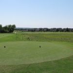 green grass with the flag in the hole.