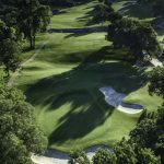 Panoramic view of a lush green golf course at Bear Creek Golf Club. Smooth