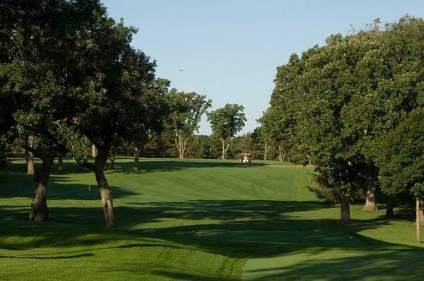 Panoramic view of a lush green golf course at Bellwood Oaks Golf Course. Smooth