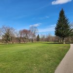 Panoramic view of a lush green golf course at Big Met Golf Course. Smooth