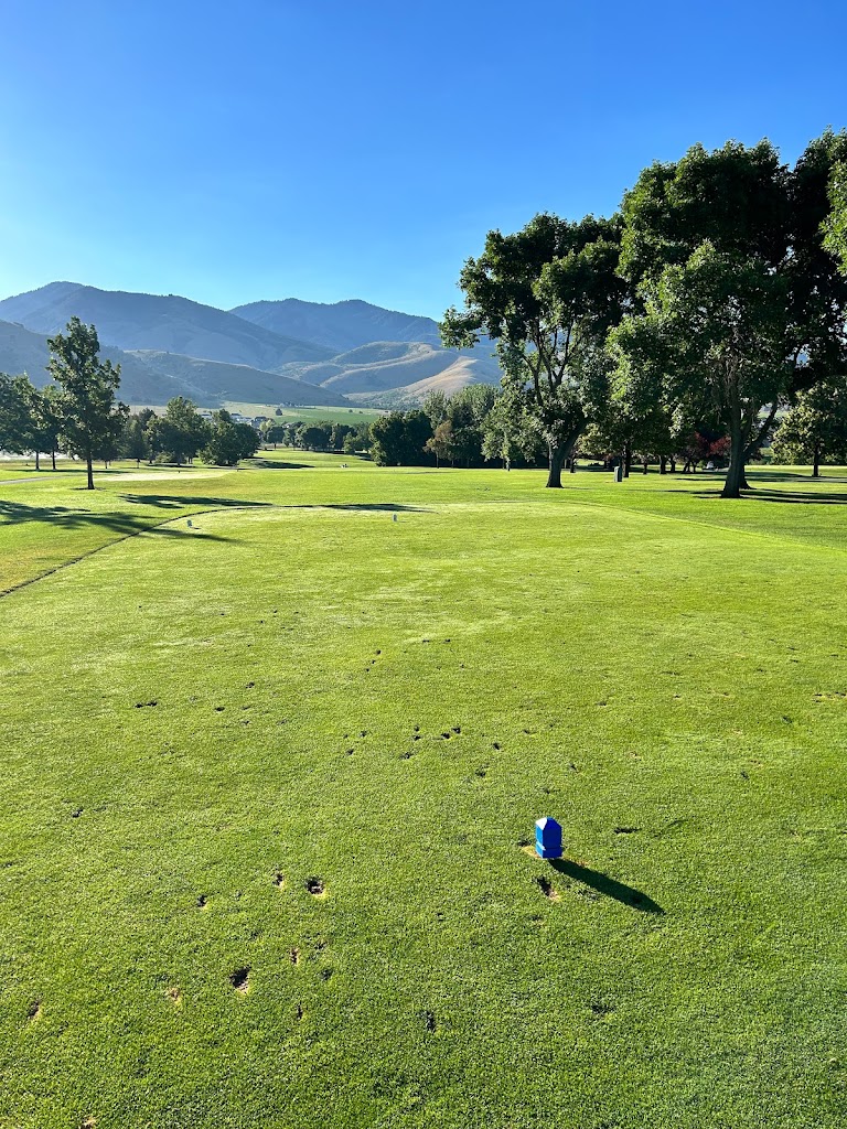 Panoramic view of a lush green golf course at Birch Creek Golf Course. Smooth