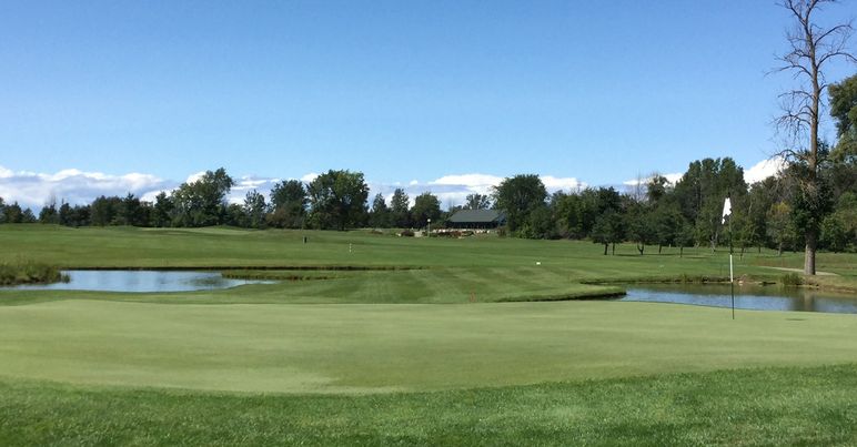 Panoramic view of a lush green golf course at Bird Creek Golf Club. Smooth
