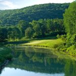 Panoramic view of a lush green golf course at Black Bear Golf Club. Smooth