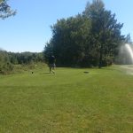 Panoramic view of a lush green golf course at Black River Golf Club. Smooth