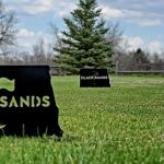 Panoramic view of a lush green golf course at Black Sands Golf Course. Smooth