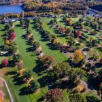 Panoramic view of a lush green golf course at Blue Hill Golf Course. Smooth